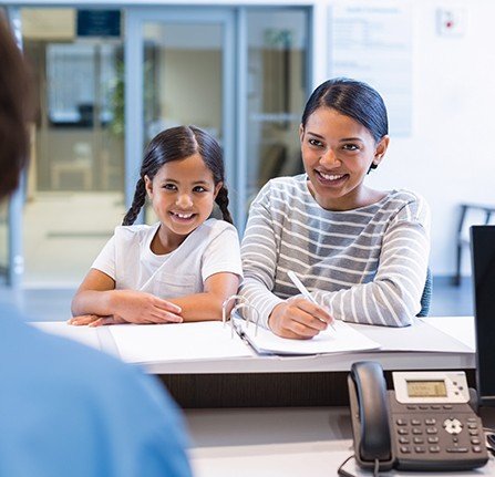 Mother and child checking in at reception desk