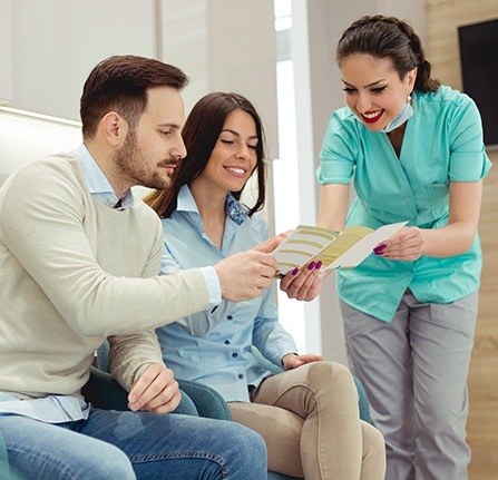 Man and woman talking to dental team member