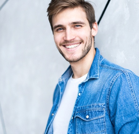 Man in denim shirt smiling with CEREC dental crowns Mt. Pleasant