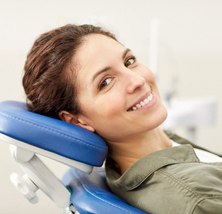 Woman with brown hair smiling in dental chair