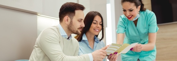 Man and woman talking to dental team member