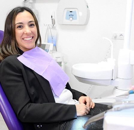 a smiling young woman sitting in a dentist chair