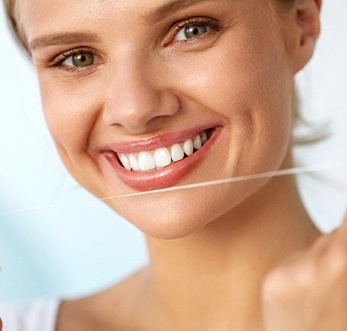 woman holding up dental floss