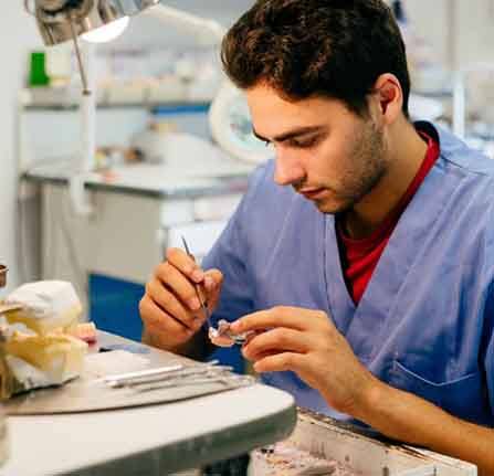 Dental lab technician artfully crafting a dental crown 