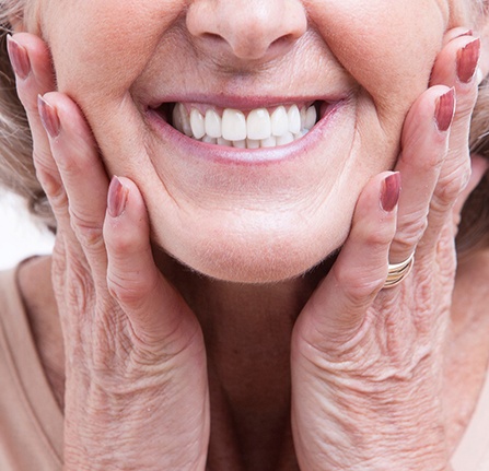 Senior smiling with her hands on her cheeks