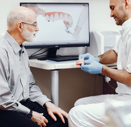 Dentist and dental patient discussing the dental implant supported denture process