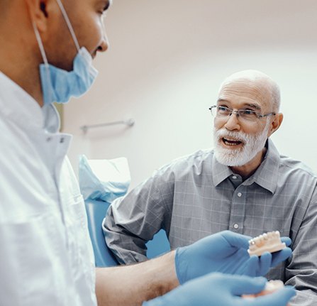 Man talking to his dentist about the cost of dental implants
