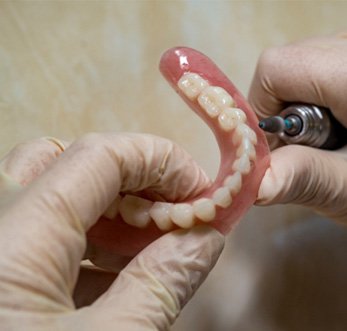 Lab technician holding dentures