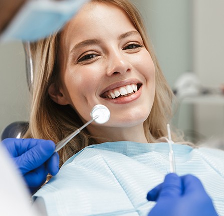 Woman in dental chair smiling during scaling and root planing visit