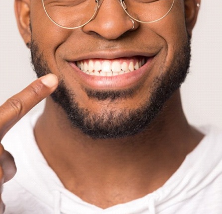 man pointing to his smile with veneers in Milwaukee